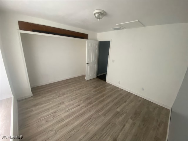 unfurnished bedroom with hardwood / wood-style flooring and a closet