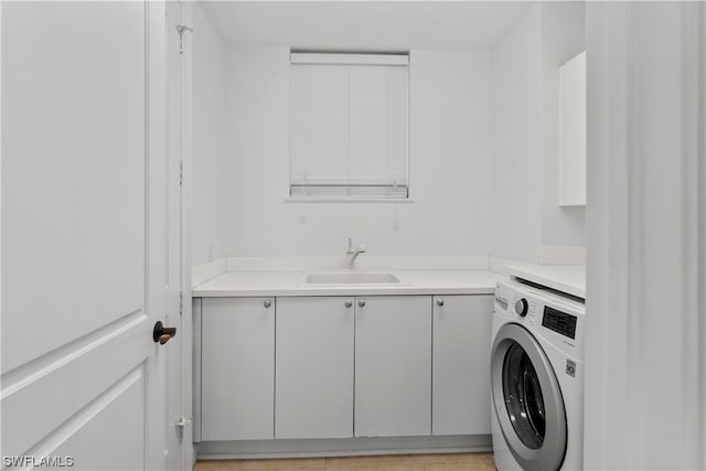 laundry area featuring cabinets, sink, and washer / clothes dryer