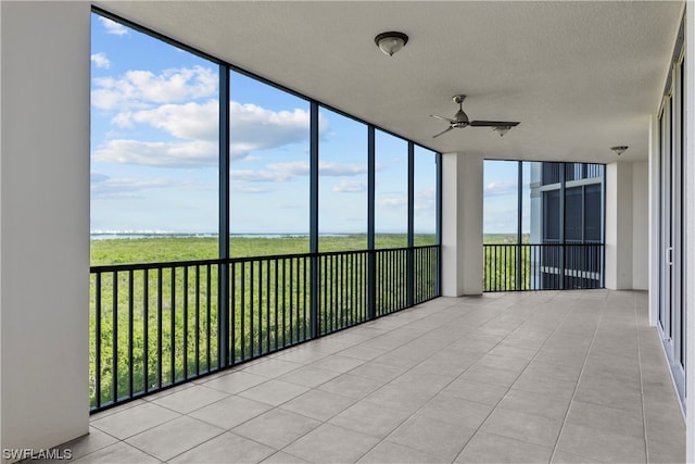 unfurnished sunroom featuring a wealth of natural light and ceiling fan