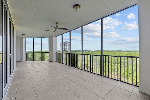 unfurnished sunroom with ceiling fan