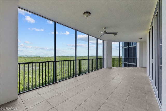 unfurnished sunroom with a healthy amount of sunlight and ceiling fan