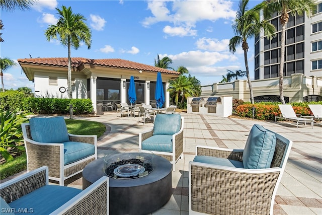 view of patio featuring an outdoor living space with a fire pit and exterior kitchen