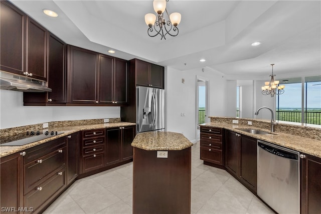 kitchen with a kitchen island, a notable chandelier, stainless steel appliances, sink, and light stone counters