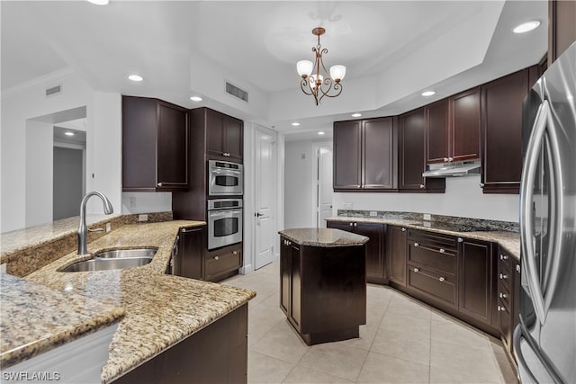 kitchen with a notable chandelier, a kitchen island, sink, hanging light fixtures, and appliances with stainless steel finishes