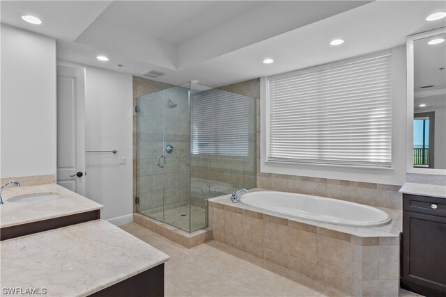 bathroom featuring tile patterned flooring, shower with separate bathtub, and vanity