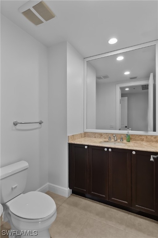 bathroom featuring tile patterned flooring, vanity, and toilet