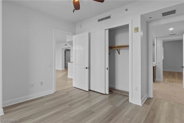 unfurnished bedroom with light hardwood / wood-style flooring, ceiling fan, and a closet