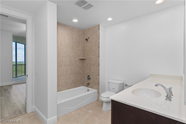 full bathroom featuring tiled shower / bath combo, vanity, toilet, and hardwood / wood-style floors