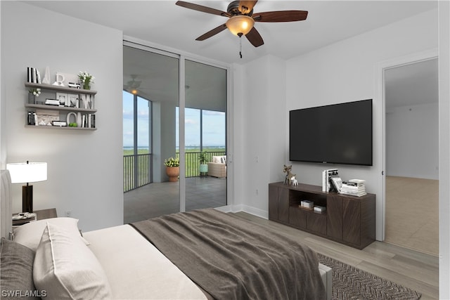 bedroom with light hardwood / wood-style flooring, ceiling fan, floor to ceiling windows, and access to outside