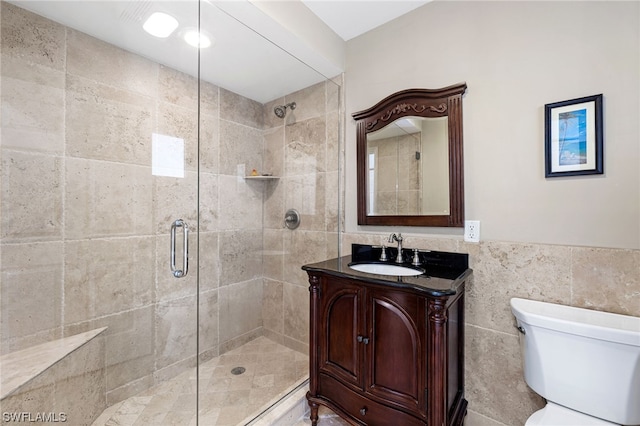 bathroom featuring walk in shower, vanity, toilet, and tile walls