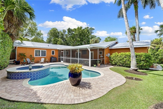 view of pool with a sunroom, a lawn, grilling area, an in ground hot tub, and a patio