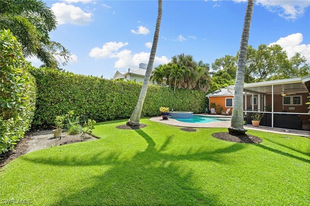 view of yard featuring a sunroom and a pool with hot tub