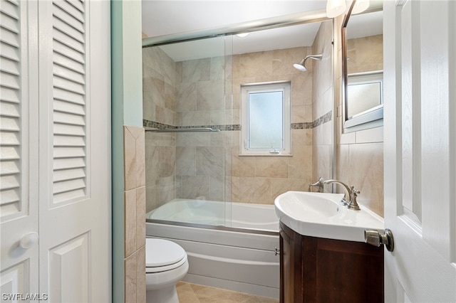 full bathroom featuring tile patterned floors, vanity, toilet, and bath / shower combo with glass door