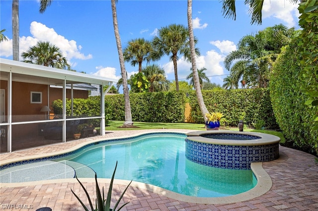 view of swimming pool with a sunroom, an in ground hot tub, and a patio