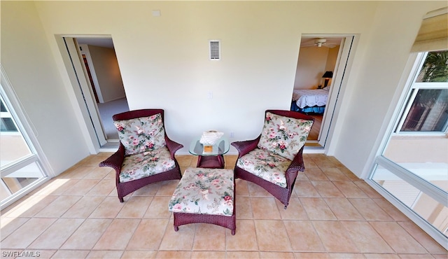 living area with light tile flooring and ceiling fan