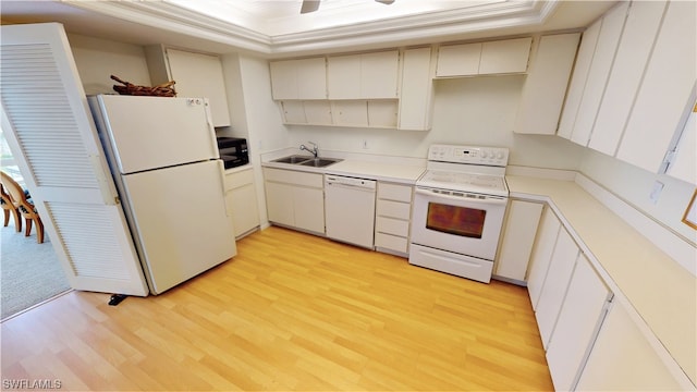 kitchen featuring a tray ceiling, ceiling fan, white appliances, sink, and light hardwood / wood-style flooring