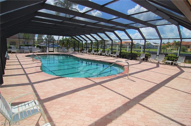 view of swimming pool with glass enclosure and a patio