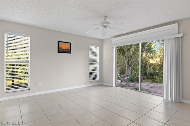 unfurnished room with light tile patterned floors, a textured ceiling, ceiling fan, and a healthy amount of sunlight