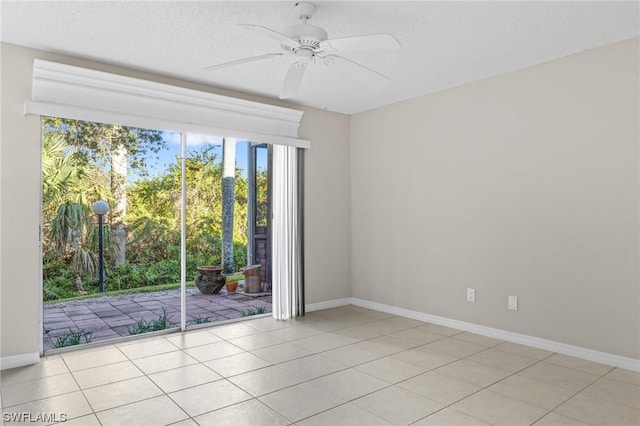 empty room featuring a textured ceiling, ceiling fan, and light tile patterned flooring