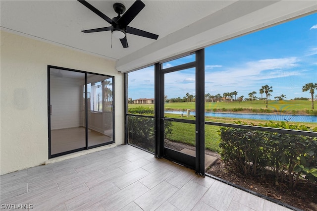 unfurnished sunroom with ceiling fan