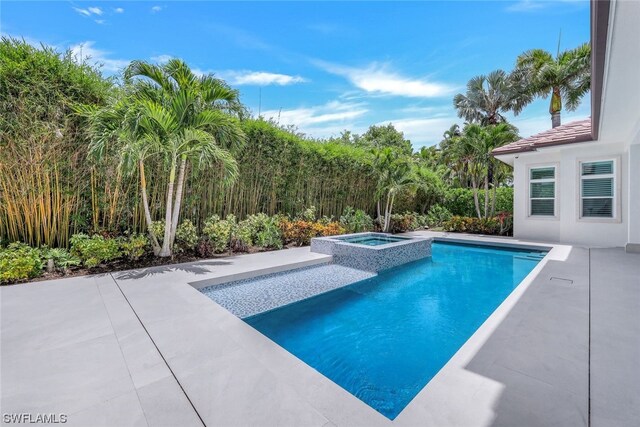 view of pool with an in ground hot tub and a patio