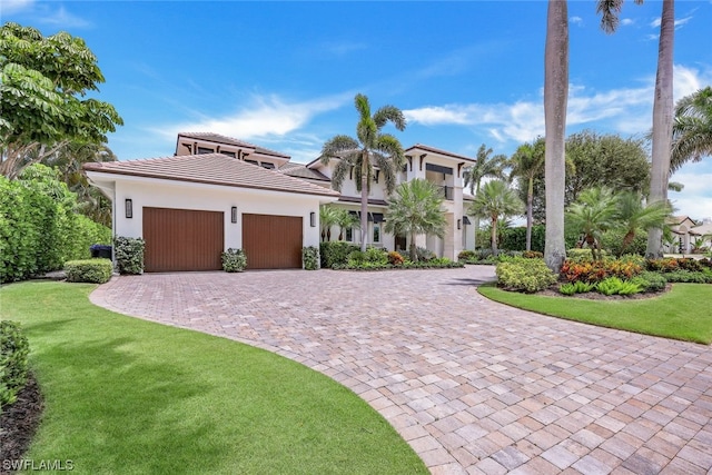 mediterranean / spanish house with a front lawn and a garage