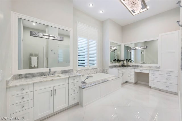 bathroom featuring tile floors, vanity, and a bath to relax in