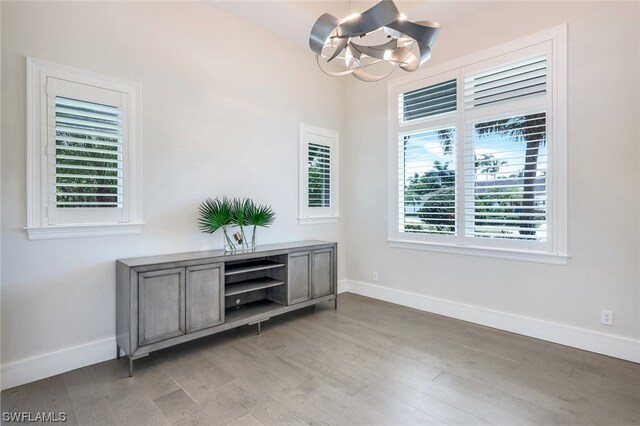 unfurnished room featuring hardwood / wood-style floors and a chandelier