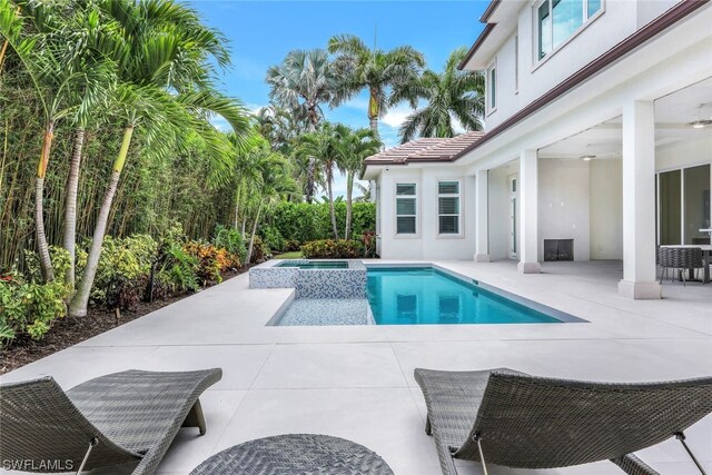 view of swimming pool featuring a patio area and an in ground hot tub