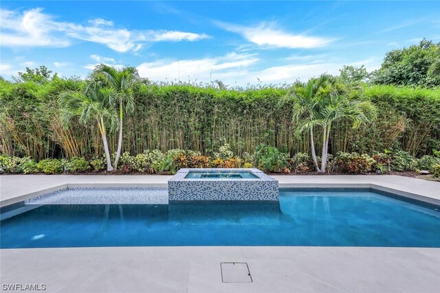 view of pool with an in ground hot tub