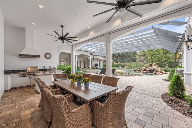 view of patio / terrace with area for grilling, an outdoor kitchen, a lanai, ceiling fan, and sink