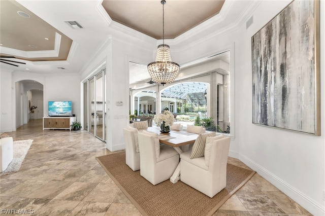 dining room featuring a raised ceiling, light tile flooring, ceiling fan with notable chandelier, and crown molding