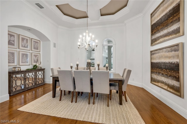 dining space featuring coffered ceiling, ornamental molding, an inviting chandelier, and dark hardwood / wood-style flooring