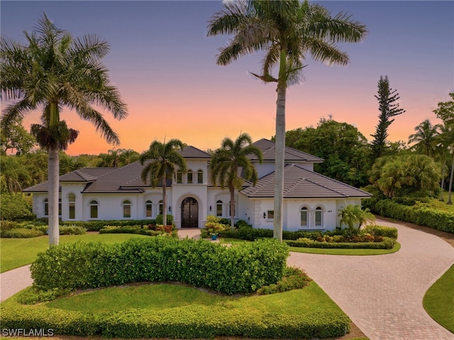 mediterranean / spanish home with a lawn