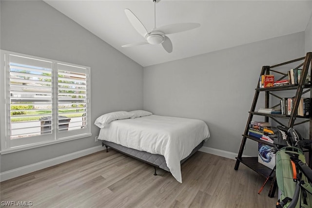 bedroom featuring light wood-style flooring, a ceiling fan, baseboards, and vaulted ceiling