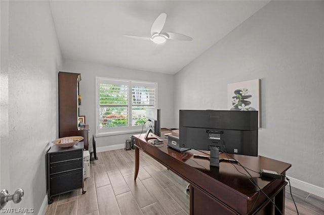 office space featuring vaulted ceiling, wood tiled floor, baseboards, and ceiling fan