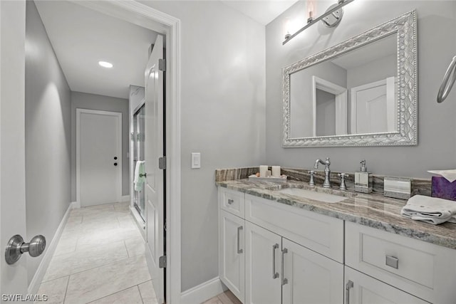 full bathroom with vanity, a shower stall, baseboards, and tile patterned floors