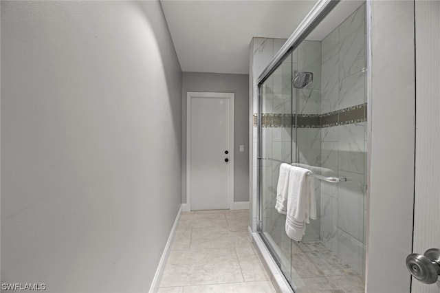 bathroom with a shower with shower door and tile patterned flooring