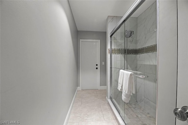 bathroom featuring a shower stall and baseboards