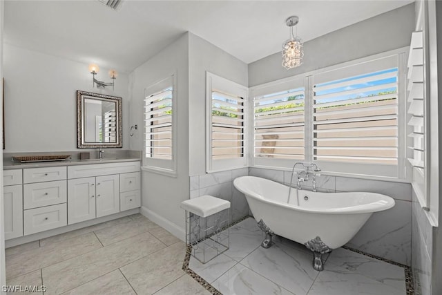 full bathroom with baseboards, a soaking tub, and vanity