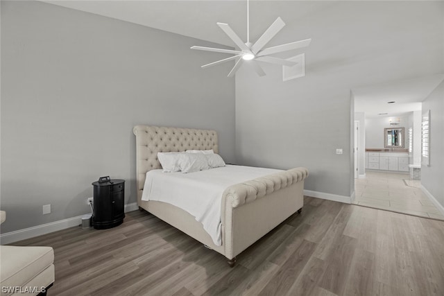 bedroom with hardwood / wood-style floors, ensuite bath, and ceiling fan