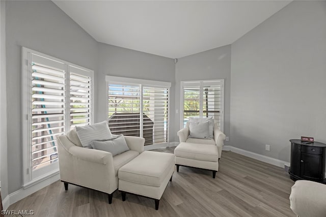 living area with light hardwood / wood-style flooring and vaulted ceiling