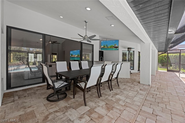 view of patio with ceiling fan and glass enclosure