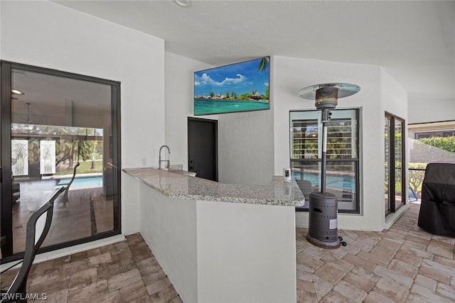 interior space featuring light stone counters and kitchen peninsula