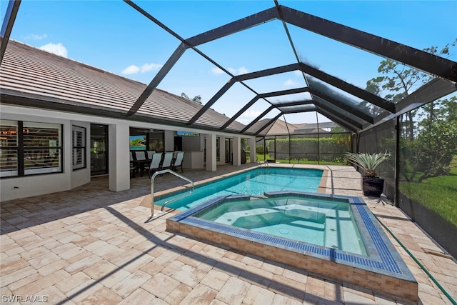 view of swimming pool featuring glass enclosure, an in ground hot tub, and a patio