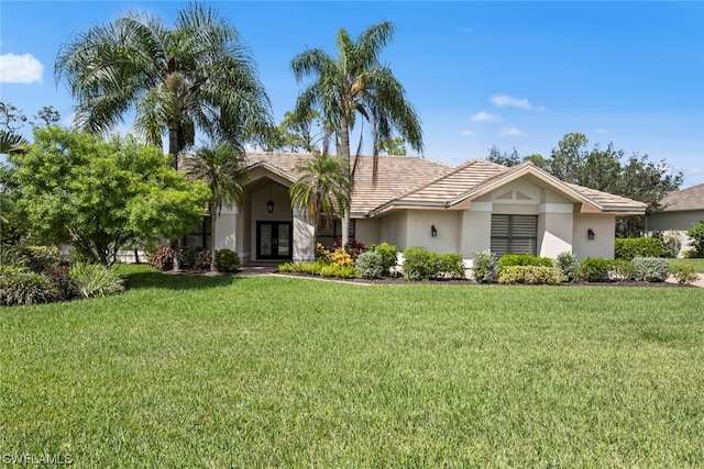 view of front of home featuring french doors, a front yard, and stucco siding