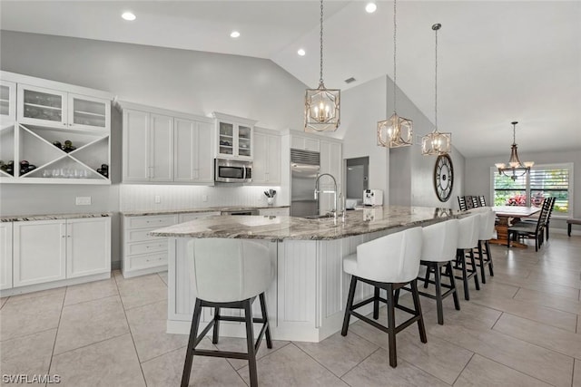 kitchen with a sink, white cabinetry, appliances with stainless steel finishes, and a chandelier