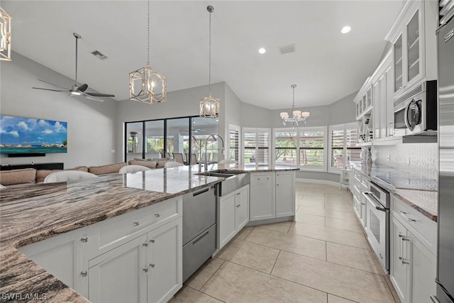 kitchen with visible vents, a sink, stainless steel appliances, white cabinets, and ceiling fan with notable chandelier