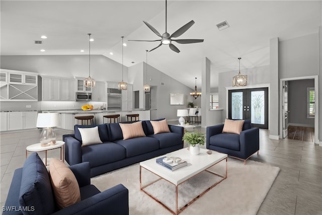 living room with ceiling fan with notable chandelier, high vaulted ceiling, and french doors