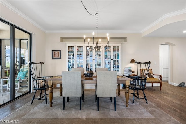 dining area featuring crown molding, hardwood / wood-style floors, and a notable chandelier